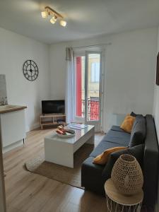 a living room with a couch and a table at L'esprit Cyrano in Bergerac