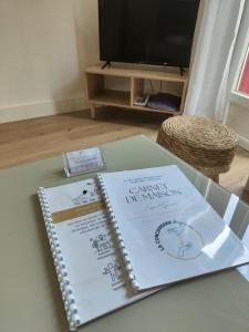 a spiral notebook sitting on a table with two wedding invitations at L'esprit Cyrano in Bergerac