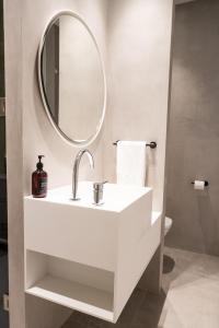 a white bathroom with a sink and a mirror at AvantiStays Porta Coeli con PARKING GRATIS in Sanlúcar de Barrameda