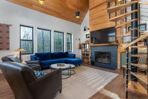 un soggiorno con un divano blu e un camino di Little Bow Cottage a Black Mountain