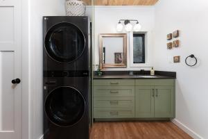 una cucina con lavatrice e asciugatrice accanto a un lavandino di Little Bow Cottage a Black Mountain Altre 32 foto