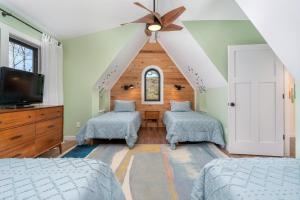 una camera da letto con due letti e un ventilatore a soffitto di Little Bow Cottage a Black Mountain