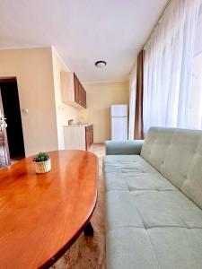 a living room with a couch and a wooden table at Vila Victoria Primorsko in Primorsko