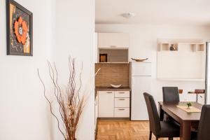 a kitchen and dining room with a table and chairs at Budva Garden Apartments in Budva