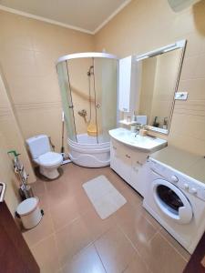 a bathroom with a toilet sink and a washing machine at Sea Whisper Apartment in Budva +7 photos