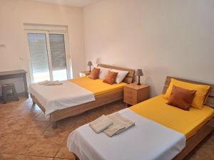 two beds in a room with yellow and white at Sea Whisper Apartment in Budva