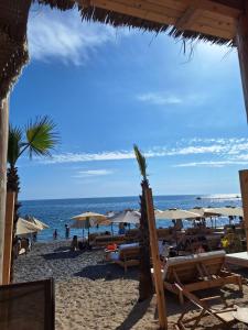 a beach with chairs and umbrellas and the ocean at Sea Whisper Apartment in Budva