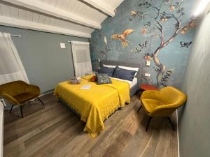sypialnia z żółtym łóżkiem i malowidłem drzewnym w obiekcie Al Sagraeto White apartment w mieście Chioggia