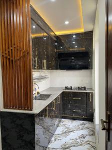 a kitchen with black marble counters and a sink at Comfort corner in Rawalpindi