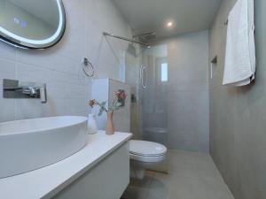 a white bathroom with a sink and a toilet at mesogios enjoyable living in Kallithea Halkidikis
