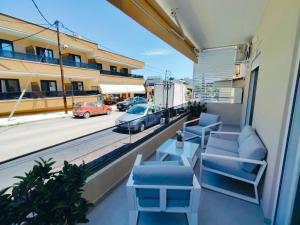 a balcony with chairs and a table and a view of a street at mesogios enjoyable living in Kallithea Halkidikis