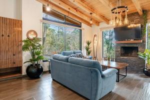 Una sala de estar con un sofá azul y una chimenea. en Cabañas Cañada del Ciervo, en Mazamitla
