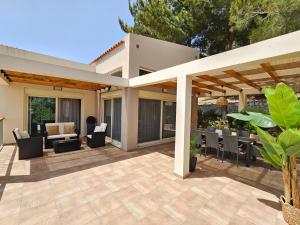 an outdoor patio with a pergola and furniture at Villa Del Monte in Arménoi