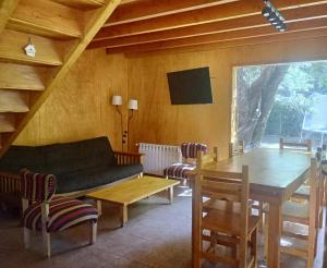 a living room with a couch and a table at Cabaña Nido del Bosque in San Carlos de Bariloche