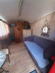 a living room with a blue couch and a table at Gites nature, Triplex et bungalow in La Houssière