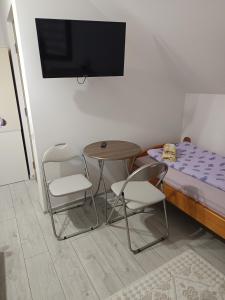 a room with a table and two chairs and a bed at Kalotaszeg Vendégház in Izvoru Crişului +36 photos