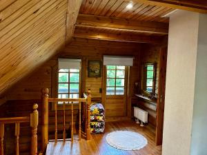 a room with a staircase in a wooden cabin at Brīvdienu māja Būmaņi in Dreiliņi