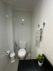une salle de bains blanche avec toilettes et lavabo dans l'établissement Lindo Flat Boa Viagem 50m do Mar, à Récife 6 autres photos