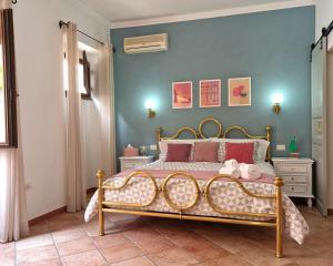 a bedroom with a bed and a blue wall at Omo Madela in Ghilarza