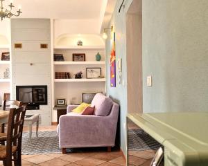 a living room with a purple chair and a table at Omo Madela in Ghilarza