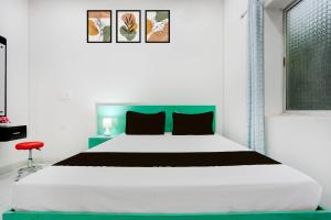 a bedroom with a large bed with a green headboard at Hotel O Online in Jāmul