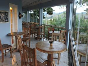 a restaurant with tables and chairs on a balcony at Pousada D'amoras in Conservatória