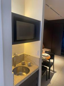 La salle de bains est pourvue d'un lavabo et d'une télévision murale. dans l'établissement Porto 2 life resort, à Porto de Galinhas