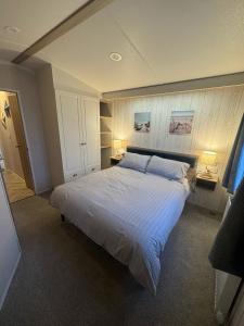 a bedroom with a large bed with two lamps at Fantasy Island - Eastgate F6 - The Ardennes with Hot Tub - Coastal Caravan Breaks in Ingoldmells