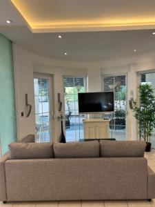 Una sala de estar con un sofá y un televisor de pantalla plana. en Belek Villa, en Belek
