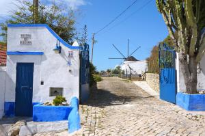 una casa azul y blanca con una puerta azul en O Remoinho, en Ericeira