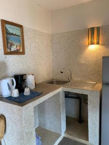 a kitchen with a counter with a sink and a refrigerator at Villa Koté Océan in Toubab Dialaw +77 photos