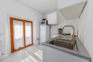 a kitchen with a stainless steel sink and a window at White Sage - Lake Como Paradise in Como