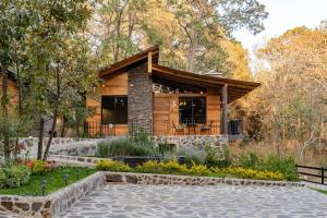 マサミトラにあるCabaña de lujo 2 habitaciones con Jacuzzi Dentro del Bosque a 10 min del Puebloの森の中のログキャビン(パティオ付)