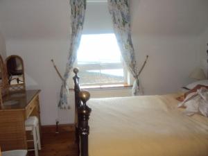 a bedroom with a bed and a large window at Sea View in Balnacart