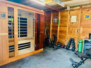 a gym with wooden walls and a room with exercise equipment at Bo's Cozy Green DADU Bungalow with shared Hot Tub, Sauna in Billings
