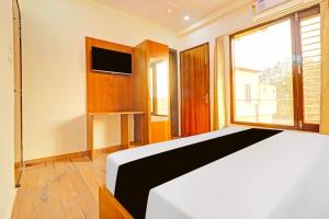 Uma cama ou camas num quarto em Hotel O Vrinda Homes mais 24 fotografias