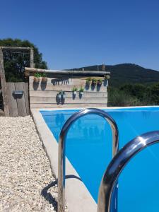 a swimming pool with blue water and some plants at Casa d' Além Turismo e Natureza - Refúgio do Bosque in Torneiro