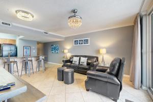a living room with leather furniture and a bar at Pelican Beach Resort 504 in Destin