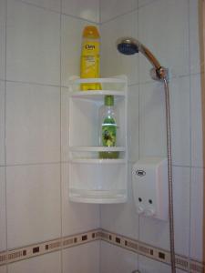 un récipient en plastique sur la paroi d'une douche dans la salle de bains dans l'établissement Apartments Cico, à Šibenik