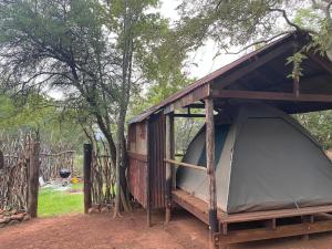 マガリスバーグにあるSoetvlei Tented Campのポーチと木のある木造の小屋