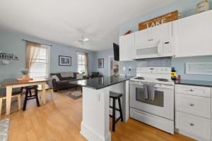 a kitchen and living room with a stove top oven at The Violet - 42 Meadow View in Cherry Valley