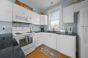 a kitchen with white cabinets and white appliances at The Violet - 42 Meadow View in Cherry Valley