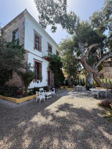 a building with tables and chairs in front of it at Akkoç Heritage Suite by Lodhous in Ayvalık