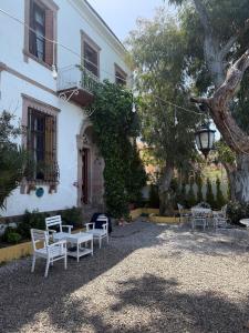 a table and chairs in front of a building at Akkoç Heritage Suite by Lodhous in Ayvalık