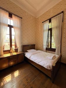 a bedroom with a bed and two windows at Akkoç Heritage Suite by Lodhous in Ayvalık