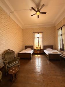 a room with two beds and a ceiling fan at Akkoç Heritage Suite by Lodhous in Ayvalık