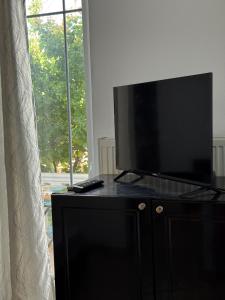 a flat screen tv on top of a dresser with a window at Angels Rooms in Ksamil