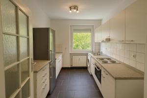 a large kitchen with white cabinets and a window at SMS-Homes I Auszeit in Heilbronn in Heilbronn
