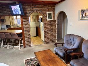 a living room with chairs and a table and a kitchen at M&D Guest House in Bellville