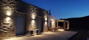 a stone house with lights on the side of it at Anesis in Ioulis